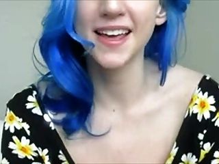 फूलों में नीली बालों वाली लड़की स्तनों के साथ खेलती है